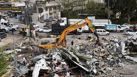 Residents inspect the site of an Israeli army demolition campaign that targeted several Palestinian commercial structures overnight, days after the issue of demolition and evacuation orders to owners, in the West Bank town of Al-Eizariya Tuesday, May 12, 2026.
