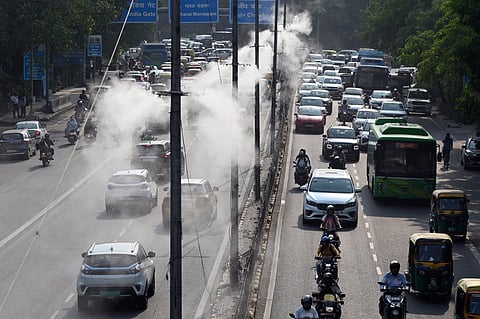 Mist in the Midst of the Heat: Sprinkles installed at ITO bring misty relief to the commuters as they battle the soaring temperatures in the national capital, in New Delhi on Monday.
