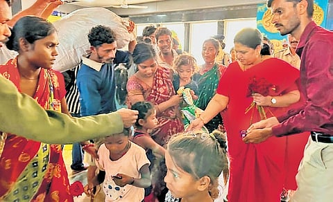 Vijayanagara district Deputy Commissioner Kavitha Mannikeri gives flowers to bonded labourers from Odisha who were rescued from brick kilns.