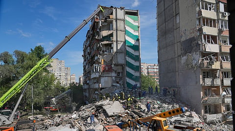 Rescuers clear the rubble after a Russian missile hit an apartment building during massive air attack in Kyiv, Ukraine, Thursday, May 14, 2026. 