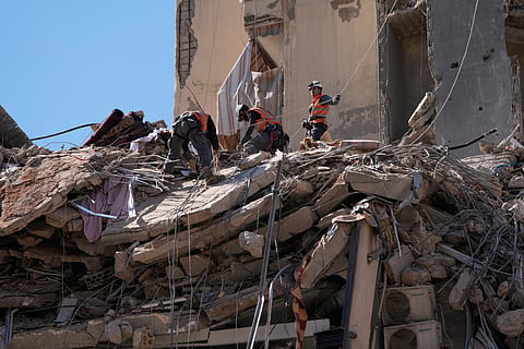 Rescue workers search through the rubble of a destroyed building that was hit in an Israeli airstrike in Dahiyeh, Beirut's southern suburbs, Lebanon, Thursday, May 7, 2026.