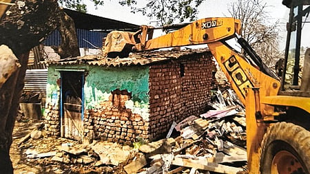 Local authorities demolishing the houses constructed on the lake area illegally in Jagalur of Davanagere district