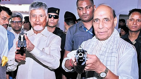 Chief Minister N Chandrababu Naidu and Union Defence Minister Rajnath Singh hold rifles at the foundation stone laying ceremony of AMCA project on Friday.