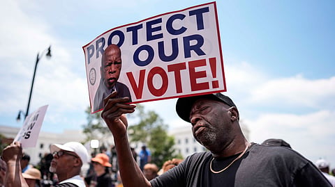 A protestor holds a sign of the late Georgia Congressman John Lewis during a voting rally, Saturday, May 16, 2026, in Montgomery, Ala. 
