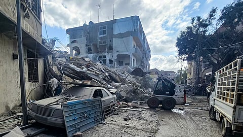 An excavator clears debris and rubble outside a damaged building following overnight Israeli bombardment on Lebanon's southern city of Tyre on May 16, 2026.