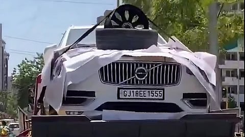 Man displays the Volvo and the alloy wheel. 