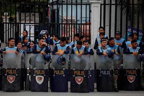 Police personnel stand behind their shields outside the Senate of the Philippines, in Manila, Thursday May 14, 2026.