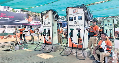 Staff of a petrol pump sit idle as customer numbers dwindled to a trickle after panic buying eased, in Bhubaneswar on Sunday 
