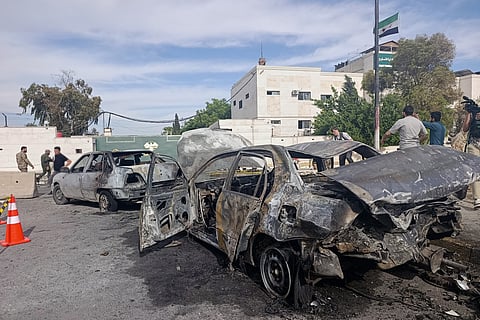 Syrian security personnel inspect the site of an explosion outside a Defense Ministry building in Damascus, Syria, Tuesday, May 19, 2026.