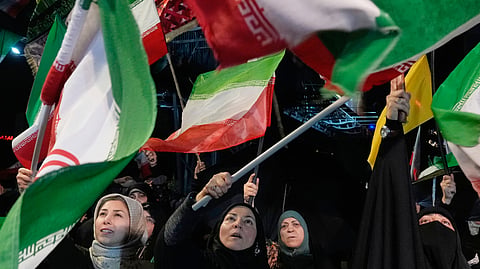 Pro-government demonstrators wave Iranian flags during their gathering at a square in downtown Tehran, Iran, Tuesday, May 19, 2026.