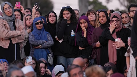 Attendees react as they listen to a speech during a vigil, the day after a shooting, outside of the Islamic Center of San Diego, Tuesday, May 19, 2026, in San Diego.