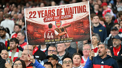 An Arsenal fan holds up a banner during the English Premier League football match between Arsenal and Burnley at the Emirates Stadium in London on Monday