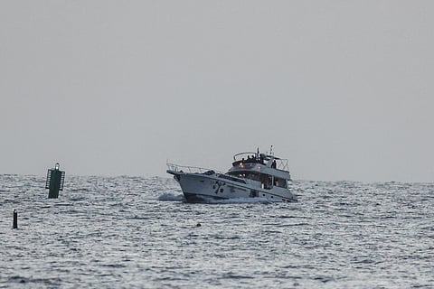 A boat bearing symbols of one of the vessels belonging to the Gaza-bound aid flotilla (L), intercepted by the Israeli navy, is motored towards the Israeli port of Ashdod, about 40 kilometres south of Tel Aviv, on May 19, 2026.