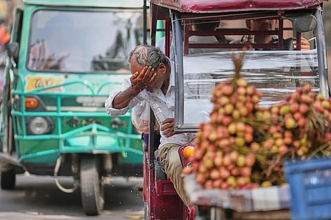 An electric rickshaw driver splashes water on his face to cook off under the intense summer heat in Lucknow, India, Wednesday, May 20, 2026. 