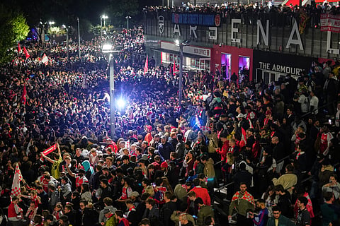 Arsenal supporters gather to celebrate at the Arsenal stadium after Arsenal's soccer team won the Premier League title in London.