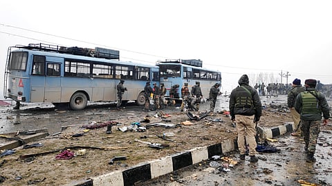 In this photo from February 14, 2019, Indian soldiers examine the debris after an explosion in Lethpora in south Kashmir's Pulwama district. 