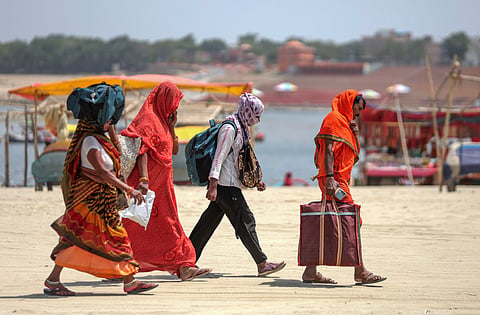  People walk with their faces covered to protect themselves from the heatwave on a hot summer day, in Prayagraj, Thursday, May 21, 2026.