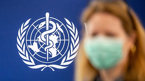 A person is wearing a protective face mask in front of the WHO logo, during the media regarding the epidemic of Ebola disease, during a press conference at the World Health Organization (WHO) headquarters in Geneva, Switzerland, Friday, May 22, 2026.