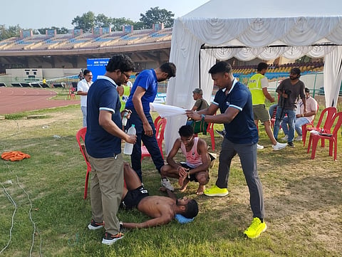 Karnataka athlete Shivaji M being attended to by officials and coaches