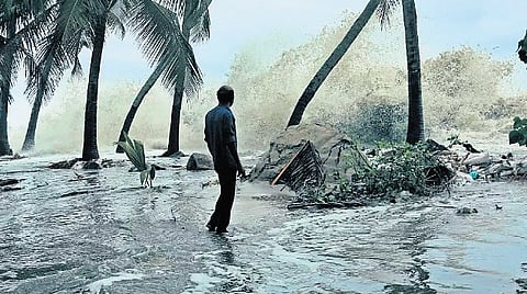 Sea waves crash against a sand barrier along the coastline in Kannamaly