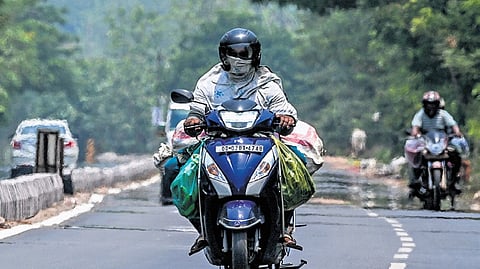 A motorist covers his face to escape the heat, in Bhubaneswar on Saturday 