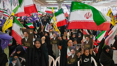 Government supporters hold Iranian flags and pictures of Iran's Supreme Leader, Ayatollah Mojtaba Khamenei, during a ceremony honoring the armed forces and those killed in the war with Israel and the U.S. at the Imam Khomeini Grand Mosque in Tehran, Iran, Sunday, May 24, 2026. 