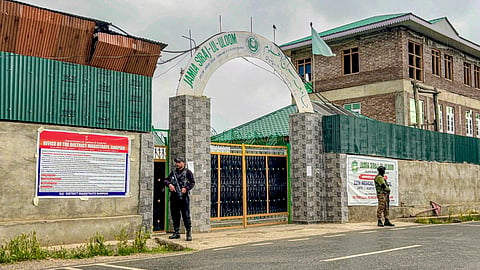 Security personnel stand guard outside Jamia Siraj-ul-Uloom during an NIA raid, in Shopian district, Jammu and Kashmir, Monday, May 25, 2026. The school was recently attached by the administration under the UAPA. 