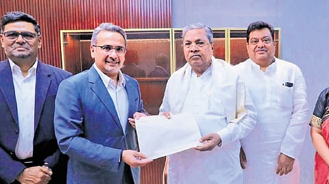 BIAL Chairman Hari Marar hands over a cheque to Chief Minister Siddaramaiah in Bengaluru on Monday 