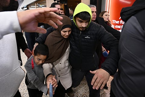 FILE - A group of supporters surround a woman and child with alleged ties to the Islamic State as they arrive at Melbourne international Airport, in Melbourne, Australia, Thursday, May 7, 2026.