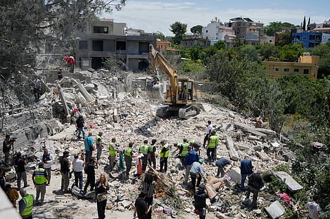 Rescue workers search for victims in the rubble of a destroyed house that was hit on Tuesday by an Israeli airstrike, in the village of Deir Qanoun al Nahr, south Lebanon, Wednesday, May 20, 2026