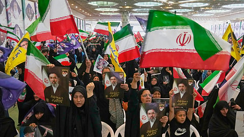 Government supporters hold Iranian flags and pictures of Iran's Supreme Leader, Ayatollah Mojtaba Khamenei, during a ceremony honoring the armed forces and those killed in the war with Israel and the U.S. at the Imam Khomeini Grand Mosque in Tehran, Iran, Sunday, May 24, 2026.