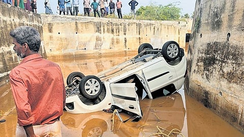 The car in which an elderly couple drowned lies overturned inside the flooded railway underpass at Enathi near Omalur in Salem on Monday.