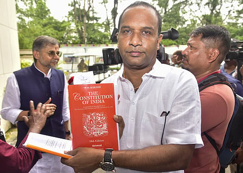 BJP MLA Kamalakhya Dey Purkayastha shows the constitution book as he arrives to attend the session of the 16th Assam Legislative Assembly, at the assembly premises, in Guwahati, Wednesday, May 27, 2026. 
