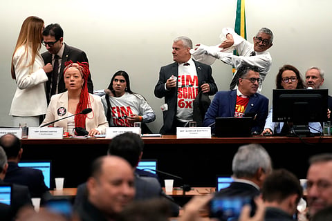 Lawmakers wear T-shirts reading in Portuguese: "End the 6x1 scale" during a special committee session analyzing the proposal at the Chamber of Deputies in Brasilia, Brazil, Wednesday, May 27, 2026. 