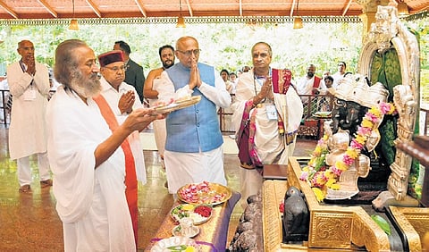 Vice-President CP Radhakrishnan takes part in a puja, led by Gurudev Sri Sri Ravishankar, during the 45th anniversary celebrations of the Art of Living International Centre in Bengaluru on Friday. Governor Thaawarchand Gehlot looks on