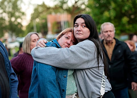Diana Winther, left, and Kellie Webber, embrace during an evening prayer and vigil in support for the victims and their families impacted by Nippon Dynawave Packaging Co. tank implosion, at R.A. Long Park in Longview, Wash., on Tuesday, May 26, 2026. 