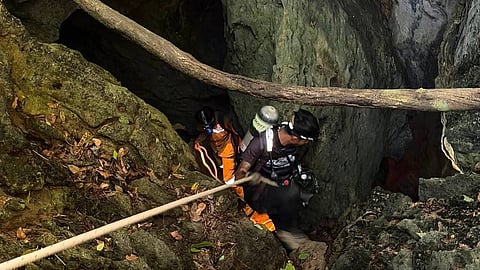 In this image released by Metta Tham Rescue Kalasin, rescuers try to reach people who have been trapped in a cave in Xaisomboun province, Laos, Tuesday, May 26, 2026.
