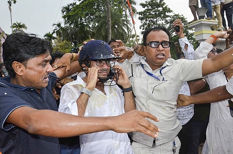 TMC General Secretary Abhishek Banerjee wears a helmet after stones, shoes and eggs were hurled at him during his visit to meet families of post-poll violence victims, in Sonarpur,