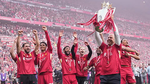 Liverpool's manager Arne Slot holds the winner's trophy as he celebrates with the players after the English Premier League soccer match between Liverpool and Crystal Palace at the Anfield stadium in Liverpool, England, Sunday, May 25, 2025.