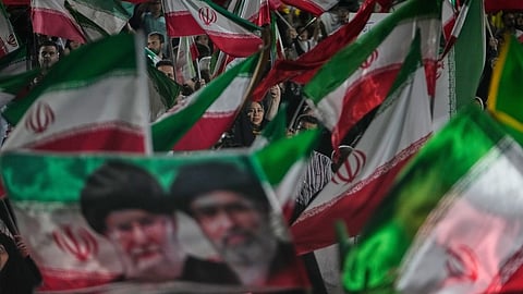 Pro-government Iranian demonstrators wave Iranian flags and a portrait of the Supreme Leader Ayatollah Mojtaba Khamenei, right, and his slain father Ayatollah Ali Khamenei in a gathering at a square in Tehran, Iran, Friday, May 29, 2026.