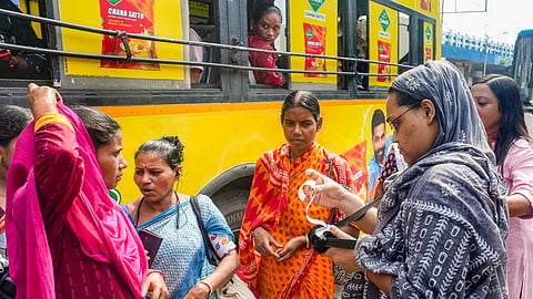 A conductor issues tickets to women passengers after the statewide free bus travel scheme for women comes into effect, in Kolkata, Monday, June 1, 2026