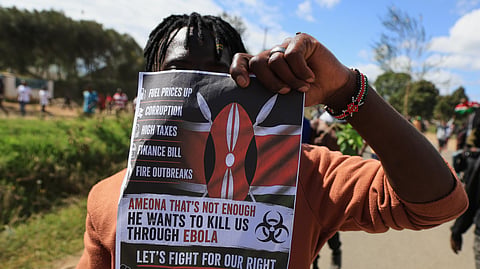A protester holds up a placard during a demonstration against a proposed Ebola quarantine center to be established by the United States at Laikipia Air Base in Nanyuki, Kenya, Monday, June 1, 2026.