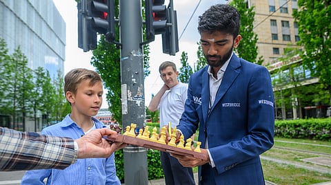 D Gukesh gives a young fan an autograph 