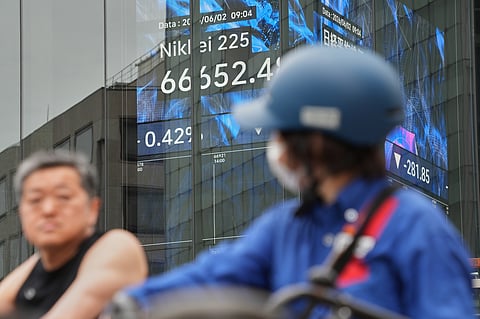 People stop in front of an electronic stock board showing Japan's Nikkei index at a securities firm Tuesday, June 2, 2026, in Tokyo.