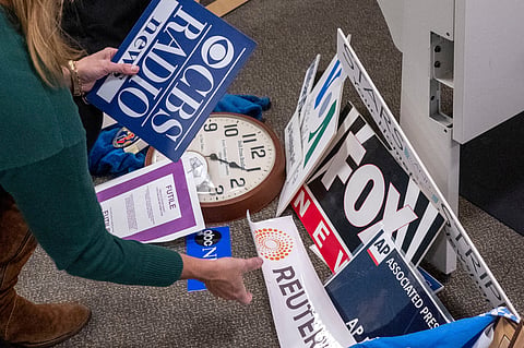 Washington Post reporter Tara Copp saves the name plaques from various news organizations as she and members of the media pack up their belongings in the press area in the Pentagon, Oct. 15, 2025 in Washington.