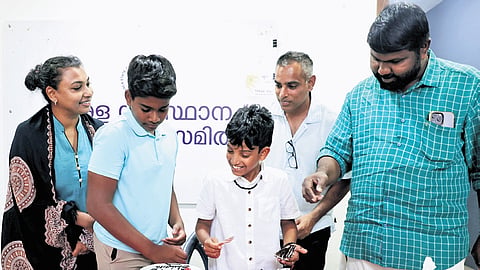 Aiden (left) and Colin cutting cake with Kerala State Council for Child Welfare general secretary G L Arun Gopi at the council office at Vazhuthacaud in Thiruvananthapuram on Wednesday. Their parents Sabu Varghese and Leena are also seen