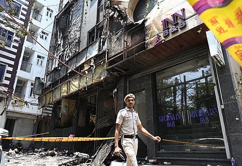 Police and Fire Brigade personnel at the site where a fire broke out in a restaurant at Malviya Nagar, in New Delhi on Wednesday