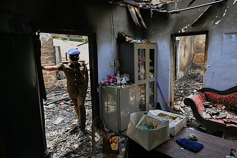 A Sri Lankan police officer inspects a charred elderly care home following an overnight fire in Anguruwatota, Sri Lanka, Thursday, June 4, 2026