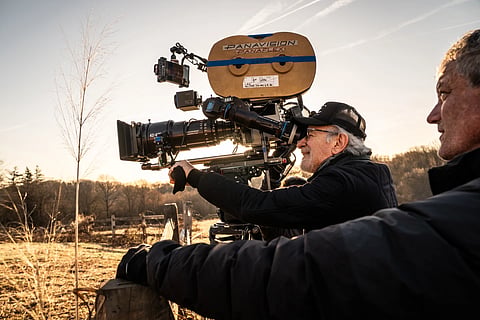 This image released by Universal Pictures shows director Steven Spielberg, center, on the set of “Disclosure Day.”
