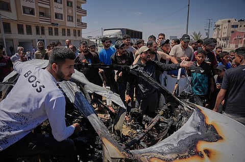 Palestinians inspect a vehicle hit by an Israeli airstrike in Deir al-Balah, in the central Gaza Strip, Tuesday, June 2, 2026.